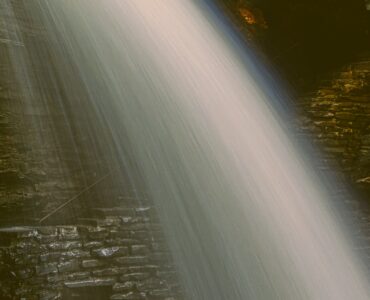 A close-up image of a waterfall in long exposure photography. Vintage style processing.